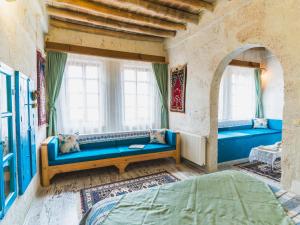 a room with a blue couch and windows at Atilla's Cave Hotel in Nevşehir