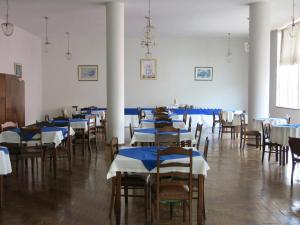 a room with tables and chairs with blue and white tablecloths at Hotel Jaú in Jaú