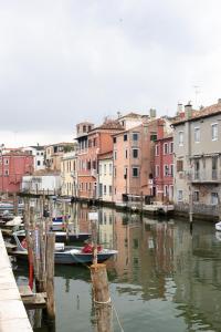 a group of boats docked in a canal with buildings at Piccola Venezia Room in Chioggia