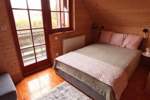 a bedroom with a bed in a wooden room at Colorful Life by STN in Balatonudvari