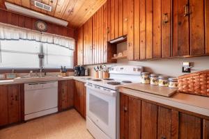 a kitchen with wooden cabinets and a white stove top oven at Mitch's Haven - Kitty Hawk MP 2, Oceanfront, 3 Bedrooms, Vintage Charming Cottage in Kitty Hawk