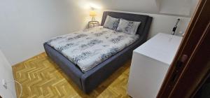 a small bedroom with a bed and a night stand at Apartman Panorama 2 in Požarevac +21 photos