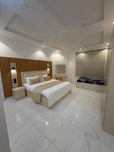 a large bedroom with a large bed and a television at النبلا الذهبي in Medina