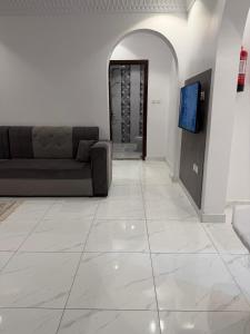 a living room with a couch and a flat screen tv at النبلا الذهبي in Medina