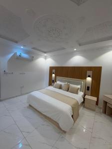 a large white bedroom with a large white bed at النبلا الذهبي in Medina
