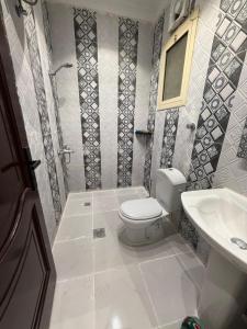 a bathroom with a toilet and a sink at النبلا الذهبي in Medina
