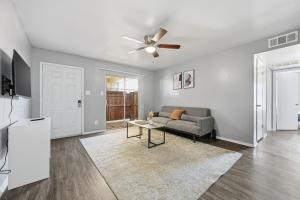 a living room with a couch and a ceiling fan at Bright two-bed wupgraded fixtures in Denton