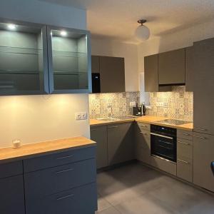 a kitchen with wooden counter tops and gray cabinets at Riverside Furth in Furth