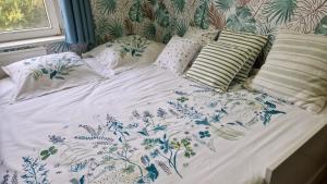 a bed with blue and white sheets and pillows at Le Nichoir de la Biesme in Aiseau