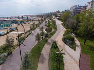 a walkway in a park next to a street at Hotel Bel Air Frontemare in Rimini +32 photos