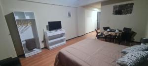 a bedroom with a bed and a television and a table at Monoambiente céntrico 02 in Asunción