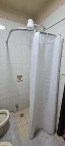a white shower curtain in a bathroom with a toilet at Monoambiente céntrico 02 in Asunción +24 photos