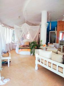 a bedroom with a canopy bed and a living room at Lady D House Watamu in Watamu +55 photos