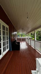 a wooden deck with a couch on a house at Casa com vista para a natureza e piscina in Garopaba