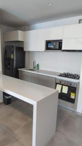 a kitchen with a white counter and a stove at Salguero sunset resort apartmento in Gaira