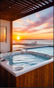 a hot tub with a sunset in the background at Salguero sunset resort apartmento in Gaira