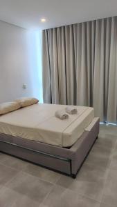 a bed sitting in a bedroom with curtains at Salguero sunset resort apartmento in Gaira