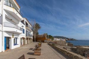 a street next to a building and the ocean at A pie de Playa, Casa de Pescadores en Calella in Calella de Palafrugell