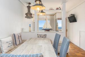 a dining room with a table and a sailboat in a window at A pie de Playa, Casa de Pescadores en Calella in Calella de Palafrugell