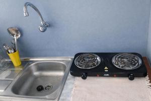 a stove top oven next to a kitchen sink at Cozy II Studio with AC and kitchen in Abomey-Calavi