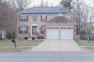 a red brick house with solar panels on the roof at Stylish Studio Escape - Calm & Convenient Lanham in Lanham +6 photos