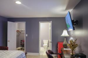 a bedroom with blue walls and a bed and a table at Stylish Studio Escape - Calm & Convenient Lanham in Lanham