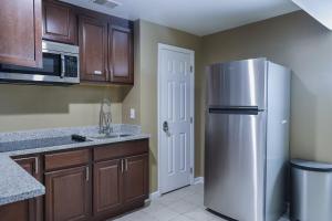 a kitchen with a stainless steel refrigerator and wooden cabinets at Stylish Studio Escape - Calm & Convenient Lanham in Lanham