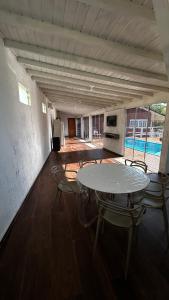 a room with a table and chairs and a kitchen at Casa com vista para a natureza e piscina in Garopaba +13 photos