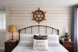 a clock on the wall above a bed at Enchanted Cottages by the Sea in Seaview