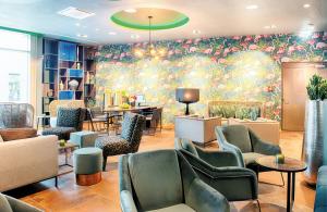 a waiting room with chairs and tables at NYX Hotel Munich by Leonardo Hotels in Munich