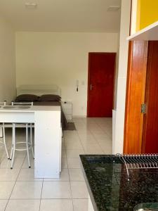 a kitchen with a white counter and a red door at Kitnet Equipada in Sao Jose do Rio Preto