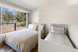 a bedroom with a bed and a window at Nanda Lake House in Bonnie Doon