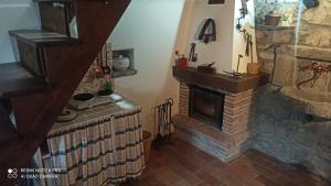 a living room with a stone fireplace and a staircase at Il BORGO DEL VENTASSO in Busana +27 photos