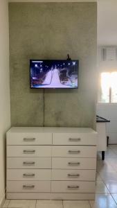 a living room with a tv on the wall at Kitnet Equipada in Sao Jose do Rio Preto +5 photos