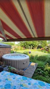 a large umbrella over a hot tub in a yard at Le Nichoir de la Biesme in Aiseau
