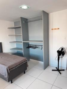 a bedroom with a bed and a desk and shelves at Margem do São Francisco 104 praiano in Petrolina