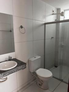 a white bathroom with a toilet and a sink at Margem do São Francisco 104 praiano in Petrolina +19 photos
