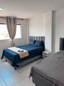 a bedroom with a blue bed and a window at Margem do São Francisco 104 praiano in Petrolina