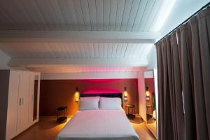 a bedroom with a large bed with a red headboard at B&B Arcolobello ApartHotel in Corato