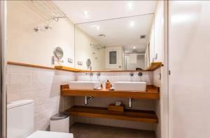 a bathroom with two sinks and a mirror at Little Dream Apartment Sitges in Sitges +24 photos