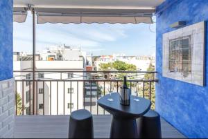 a small table on a balcony with a view of a city at Little Dream Apartment Sitges in Sitges