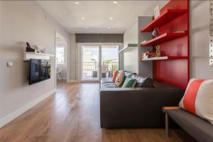 a living room with a couch and red shelves at Little Dream Apartment Sitges in Sitges