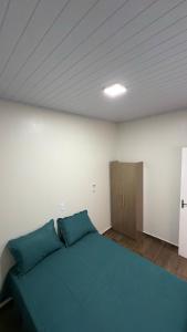a bedroom with a blue bed and a wooden cabinet at Casa privativa Próximo a Itaipu in Foz do Iguaçu