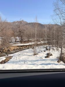 a view from a window of a snow covered field at Almaty Mountain in Almaty
