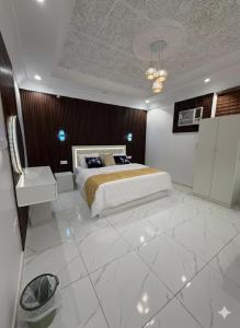 a bedroom with a bed and a white tiled floor at شقق النبلاء in Medina