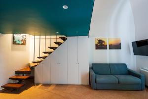 a living room with a blue couch and a staircase at B&B Arcolobello ApartHotel in Corato