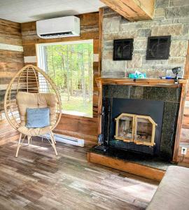 a living room with a chair and a fireplace at Chalet Le Shack O2 in Stratford