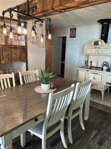 a kitchen with a wooden table and chairs and a table and a tableablish at Chalet Le Shack O2 in Stratford +11 photos