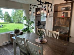 a kitchen and dining room with a wooden table and chairs at Chalet Le Shack O2 in Stratford