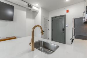a stainless steel sink in a kitchen with a door at Park Hotel 1BR Suite 402 in Chattanooga